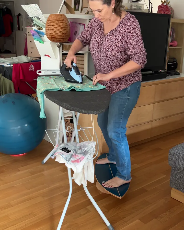 Frau bügelt auf dem Balance Board
